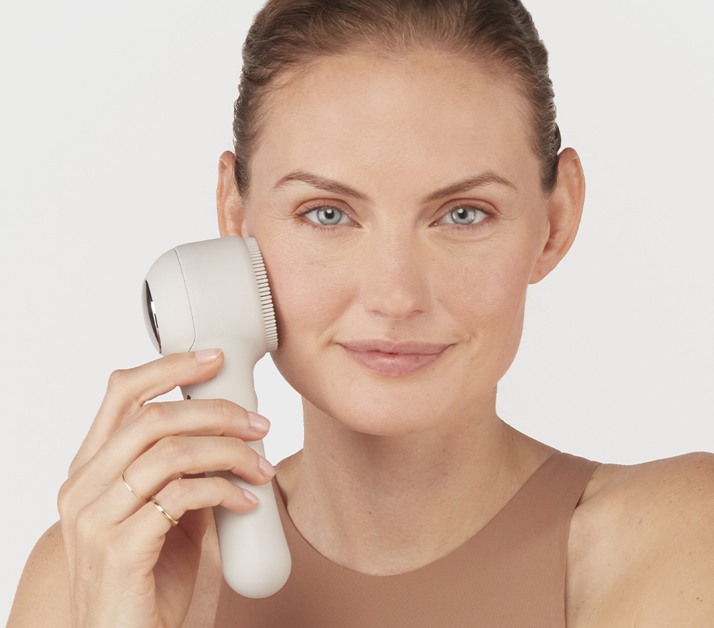 Woman using facial brush